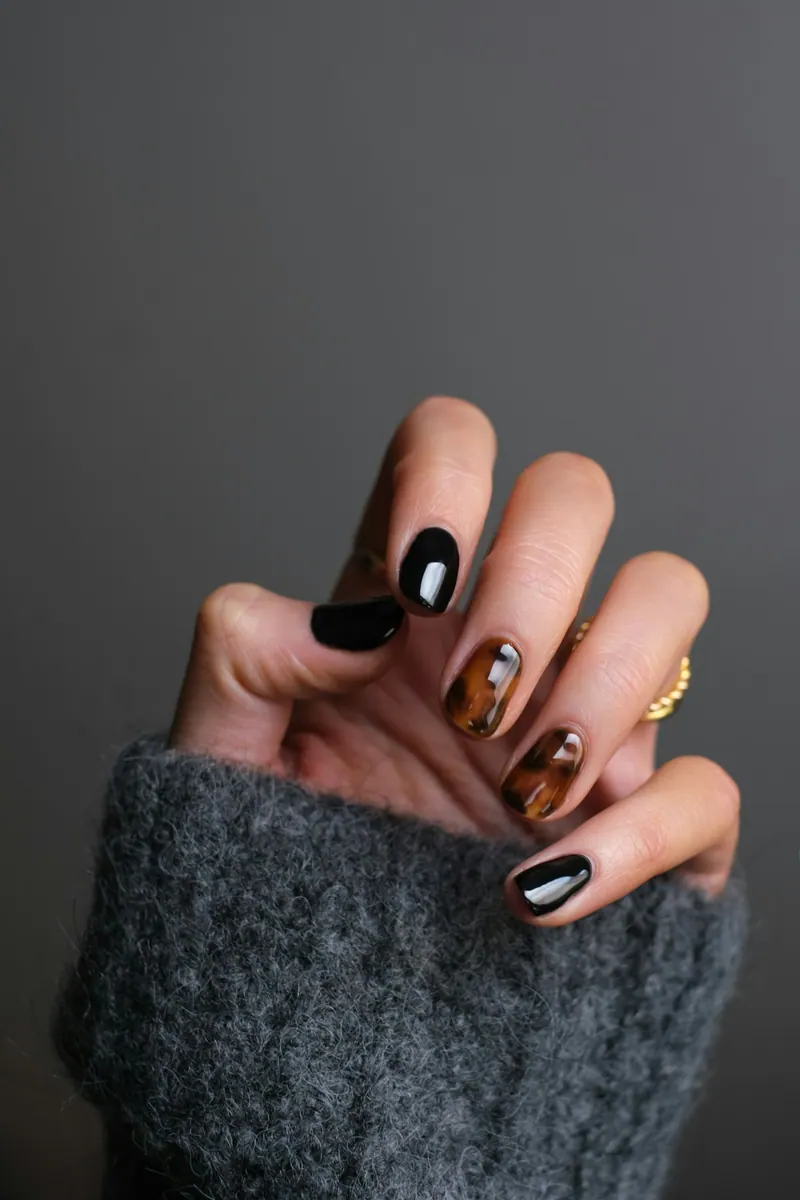 Hand with black and gold nail art