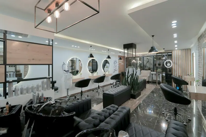 Modern salon with round mirrors, black styling chairs and pendant lights