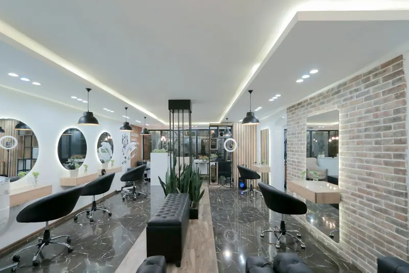 Salon interior with styling stations, round mirrors and a brick wall